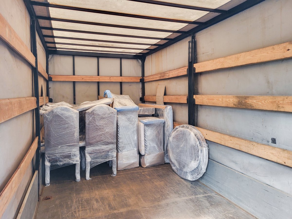 Packed furniture and boxes prepared for moving inside a truck cargo