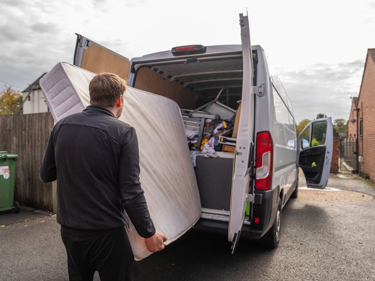 Man loading a mattress into a removal van during a house move