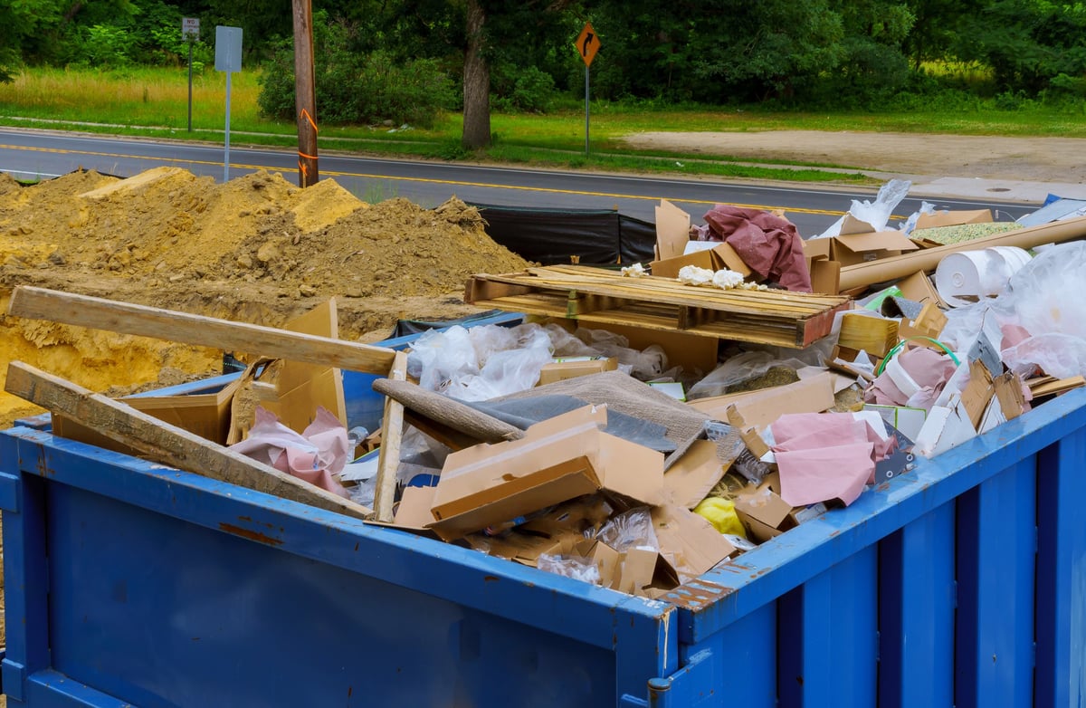 Industrial debris container being cleared during a property cleanout job