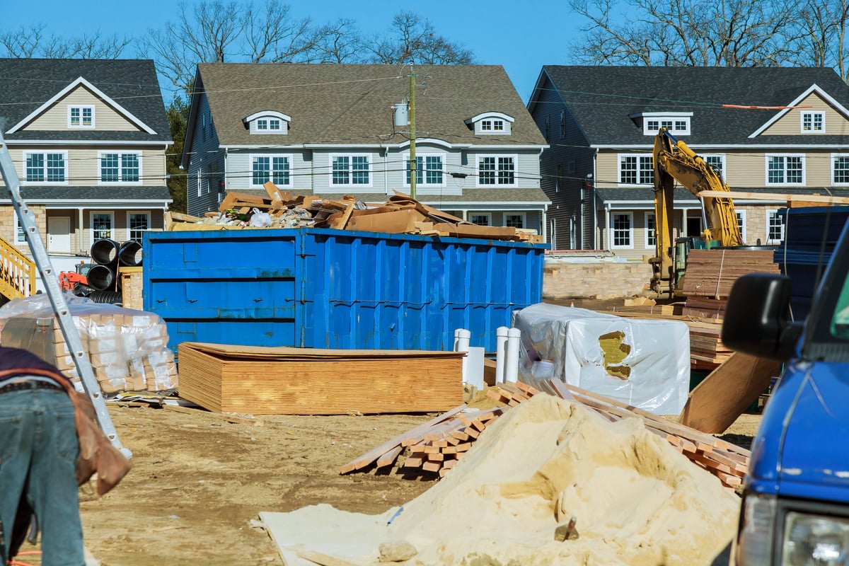Blue construction debris container filled with rock and concrete rubble